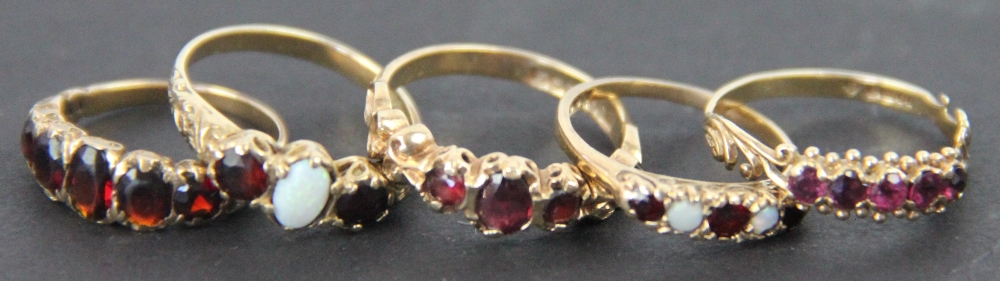 Six rings, to include; three garnet rings set in 9ct yellow gold,