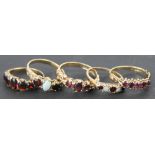 Six rings, to include; three garnet rings set in 9ct yellow gold,