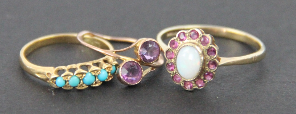 Three rings, to include; an opal and ruby oval cluster ring set in 9ct yellow gold,