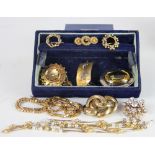 A collection of gold coloured and gold plated brooches and jewellery,