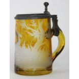 A Bohemian amber glass tankard, engraved with a recumbent stag in woodland and with pewter mounts,