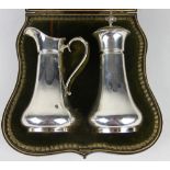 A cased silver caster and cream jug, Josiah Williams & Co London 1902, each of tapering,