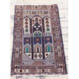 An Afghan prayer rug, worked with geometric designs in green, blue and beige,