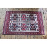 A Turkish hand woven wool rug, worked with geometric flower heads against a beige ground,