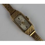 A lady's Everite 9ct yellow gold wristwatch, the rectangular face with batons and attached textured,