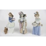 Three NAO figures, to include; a girl holding a cake her dog to her side, 18.