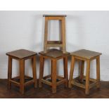 A set of four oak laboratory stools, with square seats,