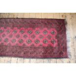 A Bokhara wool runner, worked with multiple gulls against a red ground,