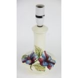 A Moorcroft Hibiscus pattern lamp base, the red and blue striped blooms against a cream ground,