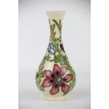 A Moorcroft vase decorated with a blue and red passion flower floral pattern, upon a cream ground,
