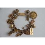 A yellow metal bracelet with attached charms, to include; a half sovereign dated 1906 in mount,