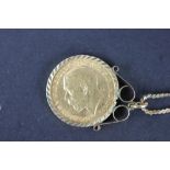 A gold sovereign dated 1912 within 9ct yellow gold scroll mount and attached 9ct gold chain