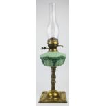 A Victorian brass oil lamp, with moulded opaque green glass reservoir, on a domed square base,