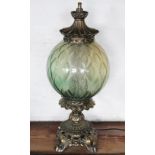 A lacquered brass oil lamp, with spherical green glass shade,