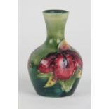 A Moorcroft Bearded Iris pattern vase, the red and purple blooms against a graded green ground,
