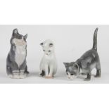 A collection of three Royal Copenhagen model cats, two grey and one white,