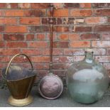 A brass coal scuttle; with a glass carboy;