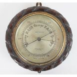 A carved oak aneroid barometer, retailed by John Baker & Co Kensington,