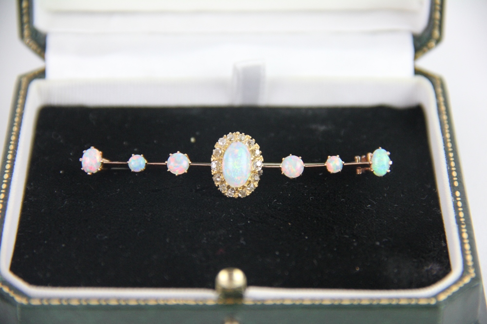 An opal and diamond bar brooch, designed as a central opal and diamond cluster,