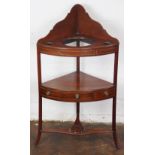 A George III inlaid mahogany three tier corner wash stand, with drawer, on out swept legs,