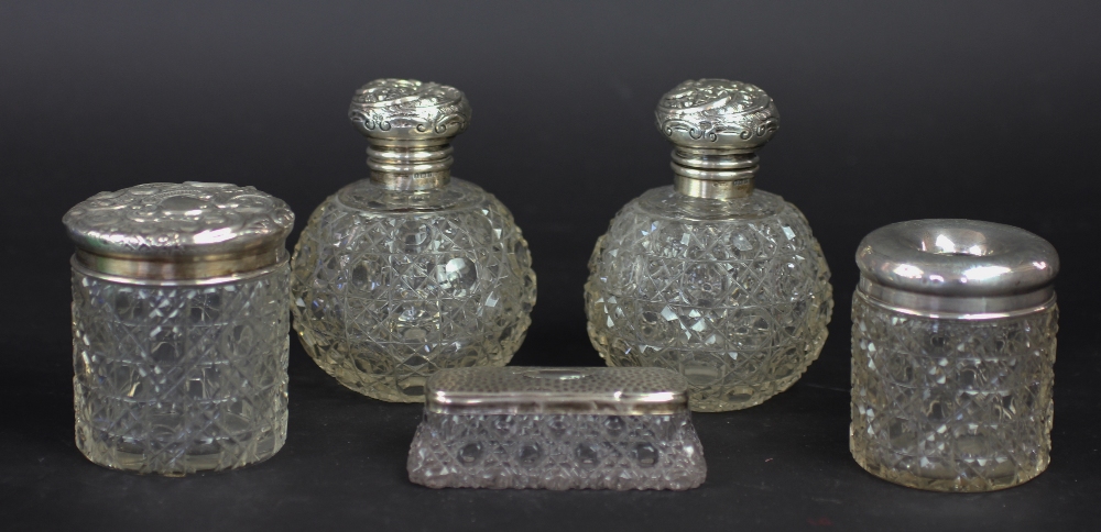 A pair of Edwardian silver mounted cut glass globular scent bottles and stoppers, Birmingham 1905,