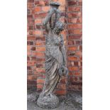 A reconstituted stone garden figural fountain of a water carrier,