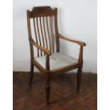 An Edwardian oak carver dining chair, with shaped spindle back and drop in seat,