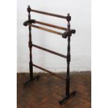A late Victorian stained beech three tier towel rail, on turned end supports,