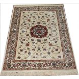 A Kashmir rug, worked with a central red medallion and foliate design against an ivory ground,