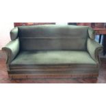 An Edwardian three seater settee, with green draylon upholstery and shaped back, on turned legs,