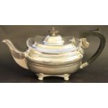 A George V silver tea pot, Sheffield, 1912, with ebonised finial and handle, on ball toes, 26.