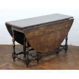 An 18th Century oak gate leg table, oval top, on turned legs and pad feet,