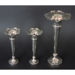 A garniture of three silver plated trumpet vases, each with flared and pierced rim, two 21.