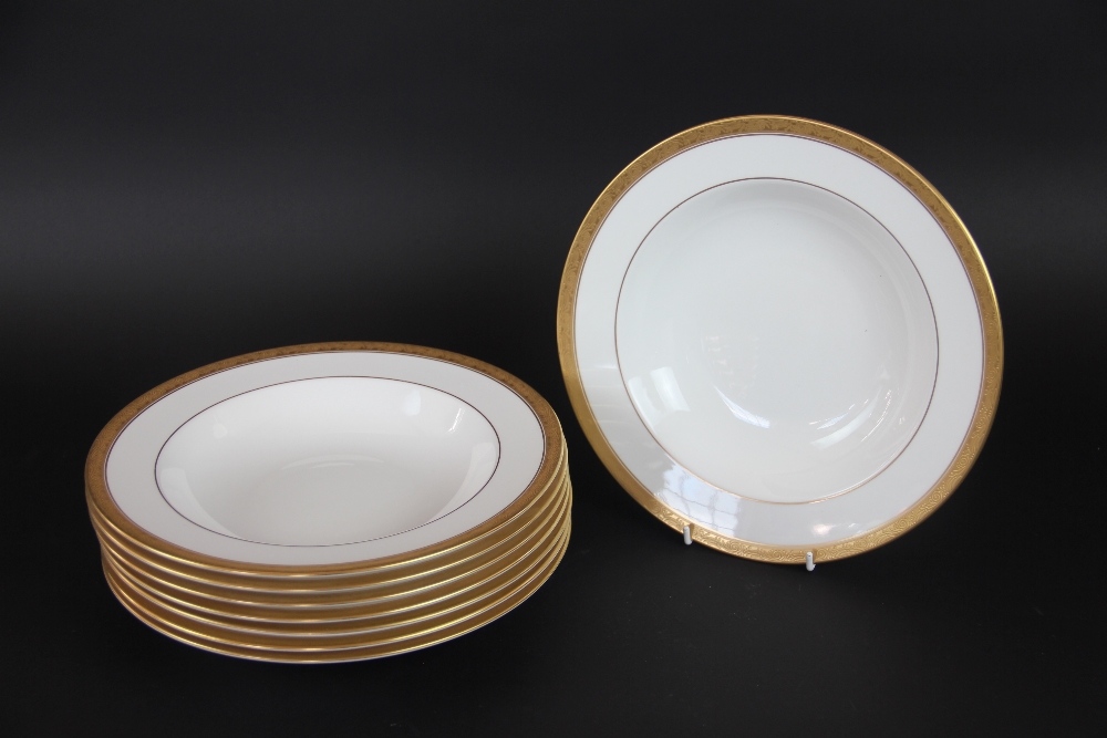 Eight Royal Worcester soup bowls with foliate gilt rims, 26.