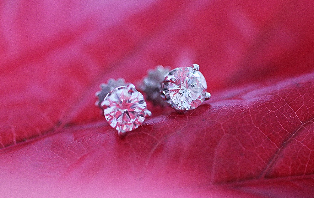 A pair of diamond solitaire stud earrings,