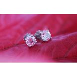 A pair of diamond solitaire stud earrings,