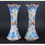 A pair of Japanese Satsuma vases, of waisted form, decorated with flowers against a blue ground,