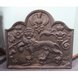 A cast iron fire back, decorated with a lion, thistle, rose and crowned fleurs de lys,