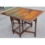 A 1920's oak gate leg table, with serpentine top, on barley twist legs,