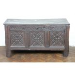 An 18th century carved oak coffer, with triple panelled front, on stile feet,