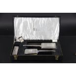 A silver four piece dressing table set, initialled and with engine turned decoration,