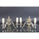 A pair of silver plated brass twin branch wall lights,