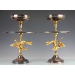 A pair of two tier silver and gold plated table centrepieces,