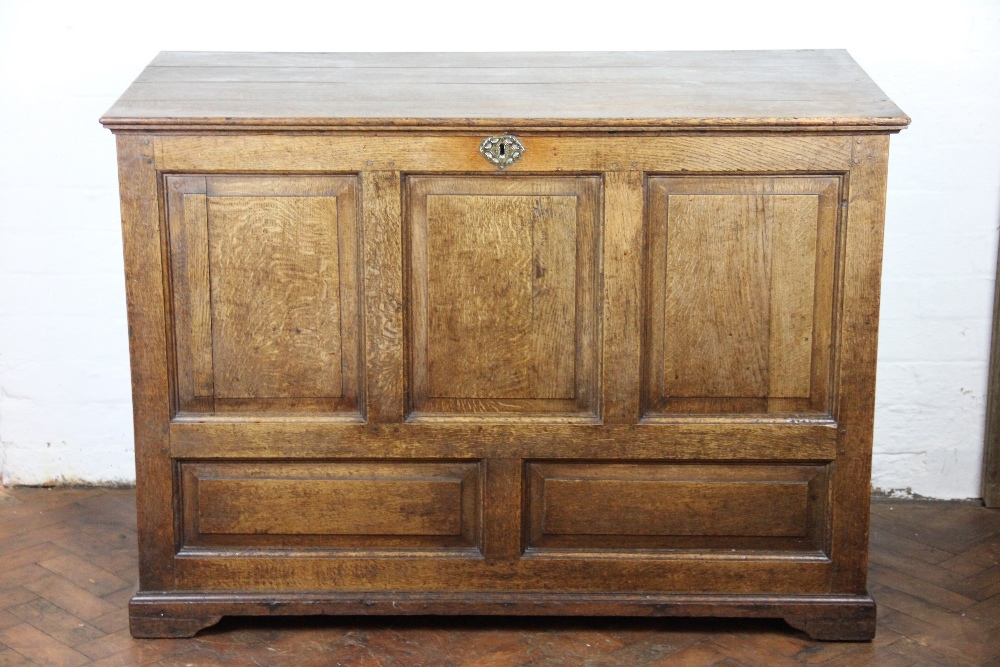A large George III oak coffer, with hinged top above a panelled front, on bracket feet, 88.
