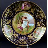 A Vienna porcelain charger, decorated with a titled scene 'spring awakening' (at fault),