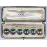 A cased set of six German silver and enamel buttons,