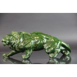 A continental pottery model of a lion with green glaze,