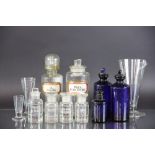 A collection of nine clear and blue glass apothecary jars and covers / stoppers,