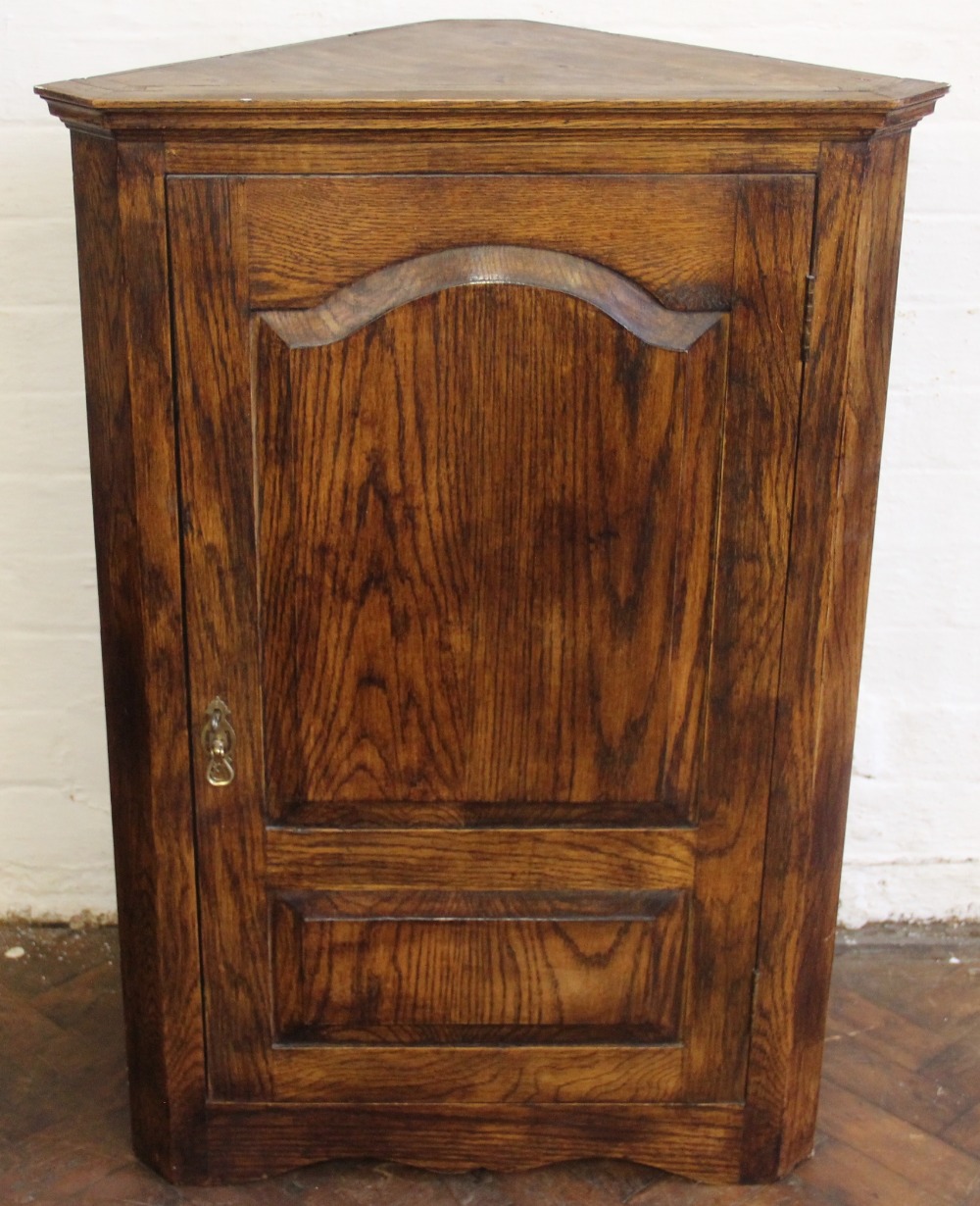 A modern pine hanging corner cabinet, with panelled door,