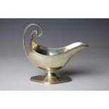 A silver sauce boat, Elkington & Co, Birmingham 1906, with scroll handle on a shaped foot, 12cm,